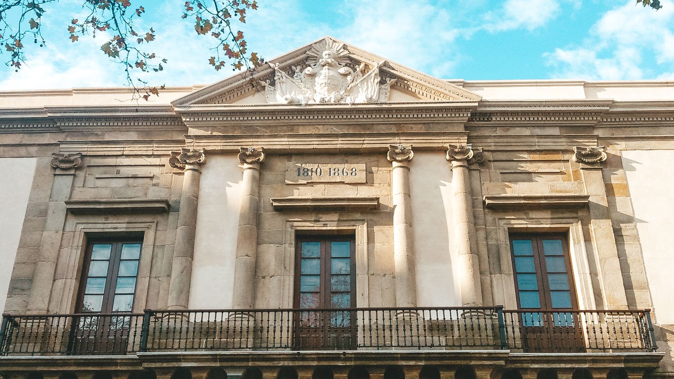 Fachada do Cabildo de Montevidéu, destacando suas colunas clássicas e detalhes arquitetônicos ornamentados. A inscrição "1808" pode ser vista no topo, refletindo a importância histórica do edifício.